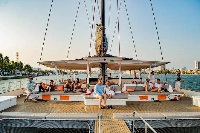 Gäste entspannen auf dem Deck eines Katamarans vor der Skyline von Cartagena